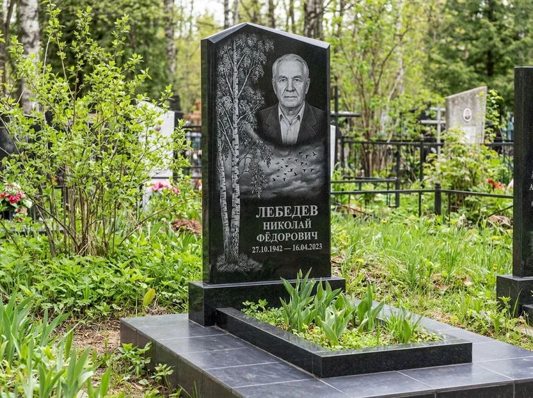 Памятник с гравировкой берёзы: вертикальная стела со скошенным верхом — берёза и стая птиц в небе, гранитный цоколь с тёмной плиткой, работа «Лебедев» в Тольятти