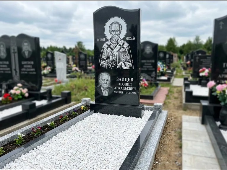 Памятник с гравировкой иконы: стела с крестообразным навершием — икона в резной рамке-киоте, газон без ограды, стриженая трава, работа «Раевская» в Тольятти