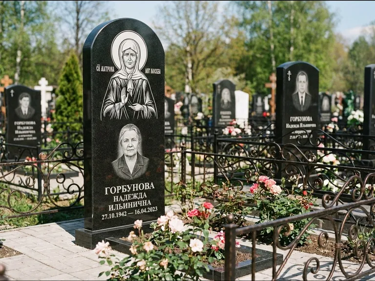 Памятник с гравировкой иконы: стела с арочным верхом и киотом под образ — гравировка образа Матроны Московской, гранитный цоколь с тёмной плиткой, работа «Ковалёв» в Тольятти