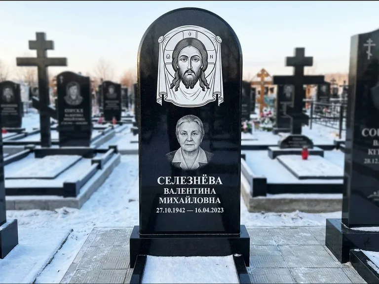 Памятник с гравировкой иконы: небольшая скромная одиночная стела с именной иконой — золочёный нимб на образе, аккуратный участок с газоном, работа «Ковалёв» в Тольятти