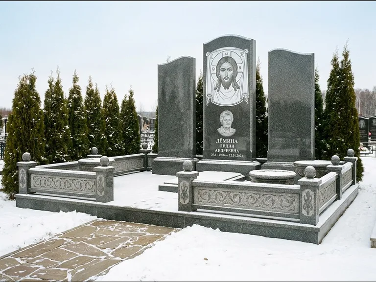 Памятник с гравировкой иконы: узкая вертикальная стела-пилон с ликом — икона в резной рамке-киоте, открытая лужайка без ограды, работа «Одинцов» в Тольятти